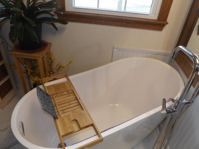 bathroom with a tub and a healthy amount of sunlight