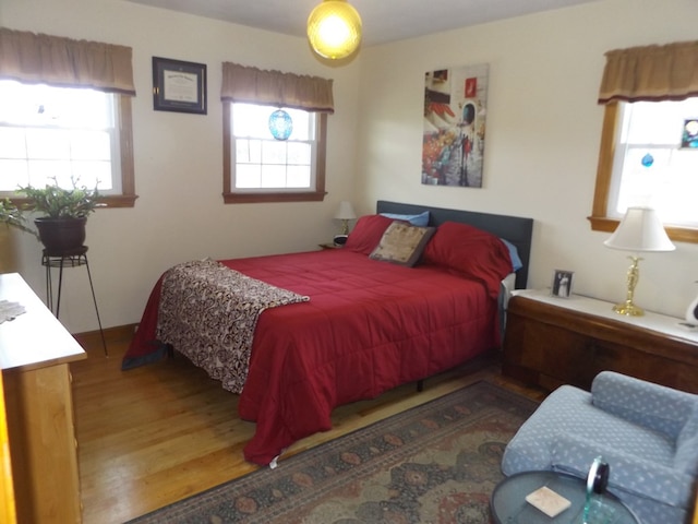 bedroom featuring multiple windows and hardwood / wood-style flooring