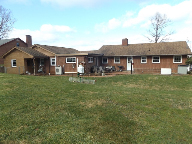 back of property with ac unit, a yard, and cooling unit