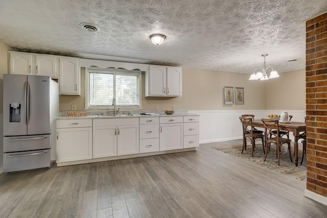 103 Whites Subdivision Rd, Cedar Bluff, VA 24609 - kitchen with stainless steel fridge with ice dispenser, a sink, light wood finished floors, a textured ceiling, and light countertops
