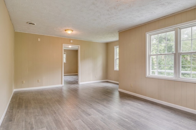 103 Whites Subdivision Rd, Cedar Bluff, VA 24609 - unfurnished room featuring wood finished floors, a textured ceiling, baseboards, and wooden walls