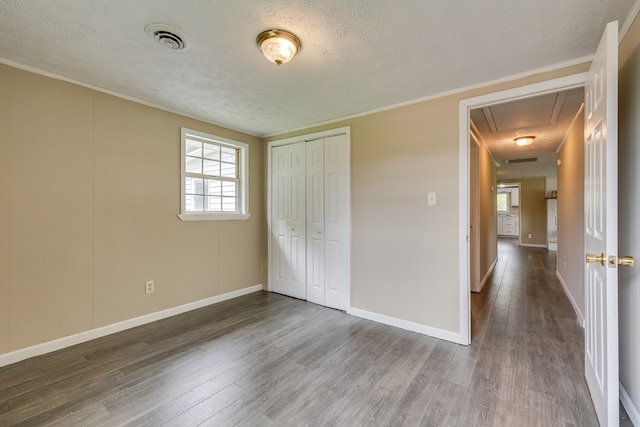 103 Whites Subdivision Rd, Cedar Bluff, VA 24609 - unfurnished bedroom with attic access, wood finished floors, a textured ceiling, baseboards, and crown molding