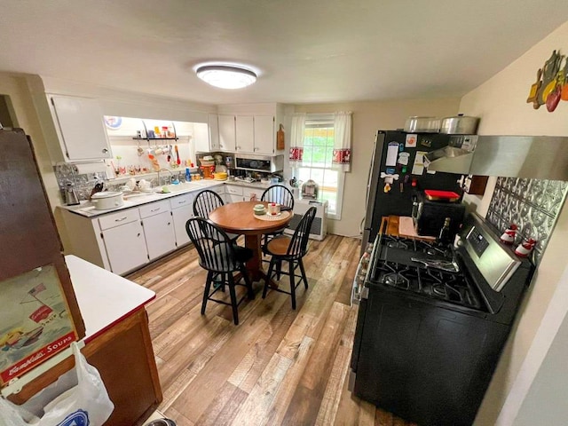 232 Echo Ridge Ln, Elk Creek, VA 24326 - kitchen featuring gas stove, light wood-style floors, white cabinets, ventilation hood, and light countertops