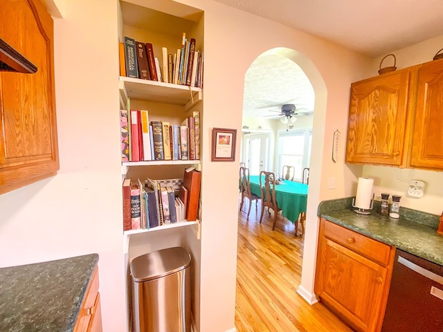 1476 E Blue Grass Trl, Bland, VA 24315 - kitchen featuring dishwashing machine, light wood-style floors, ceiling fan, arched walkways, and brown cabinetry