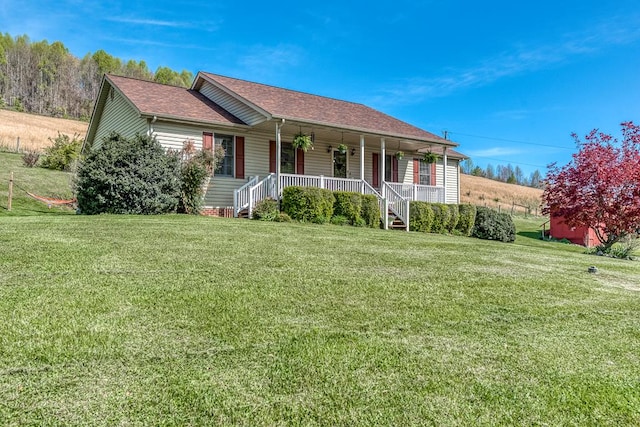ranch-style home featuring a front lawn, a porch, and a shingled roof