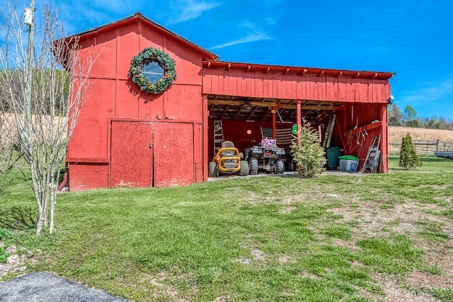 view of pole building with fence and a yard