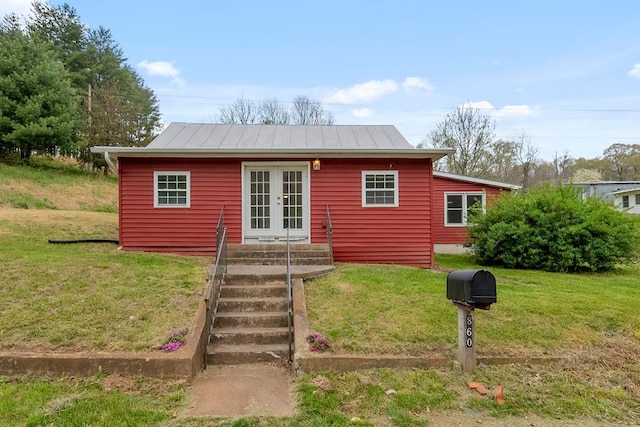 view of front of home featuring french doors, a front yard, a standing seam roof, and metal roof
