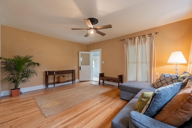 living area with wood finished floors, ceiling fan, and baseboards