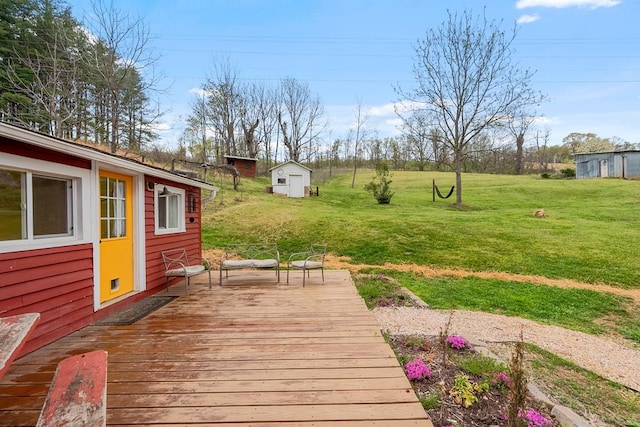 wooden terrace featuring a yard, an outbuilding, and a storage unit