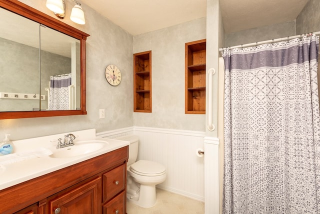 full bath featuring vanity, a shower with curtain, wainscoting, tile patterned floors, and toilet