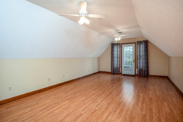 bonus room with baseboards, lofted ceiling, a ceiling fan, and light wood finished floors