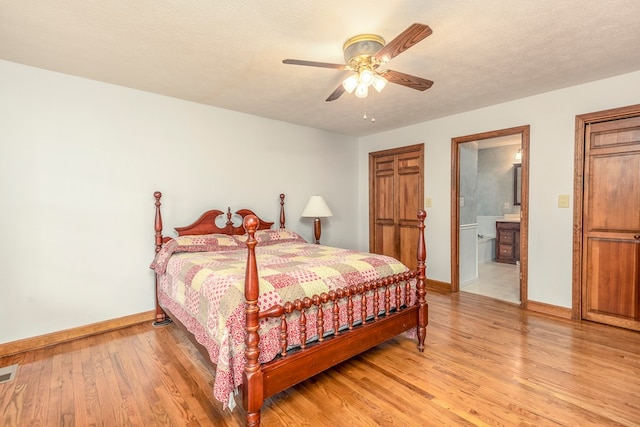 bedroom with visible vents, light wood-style flooring, a textured ceiling, and baseboards