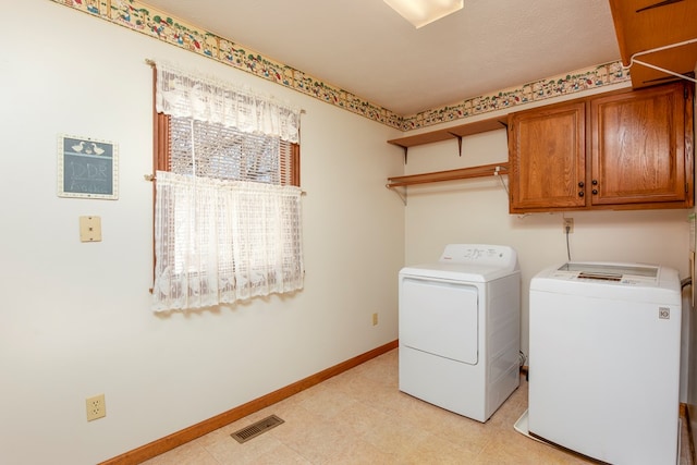 clothes washing area featuring washing machine and clothes dryer, visible vents, baseboards, light floors, and cabinet space
