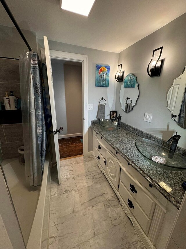 196 Goodwin Rd, Cedar Bluff, VA 24609 - bathroom with marble finish floors, double vanity, toilet, curtained shower, and baseboards
