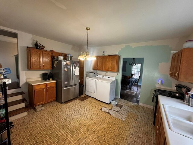 196 Goodwin Rd, Cedar Bluff, VA 24609 - kitchen featuring freestanding refrigerator, a chandelier, washing machine and dryer, and brown cabinets