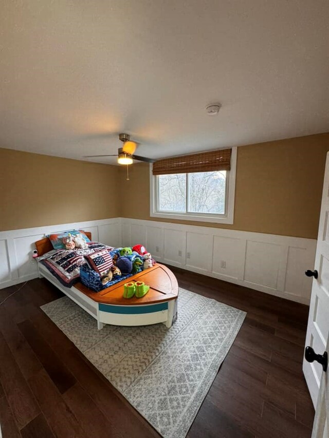 196 Goodwin Rd, Cedar Bluff, VA 24609 - bedroom with a wainscoted wall, a decorative wall, dark wood finished floors, and ceiling fan
