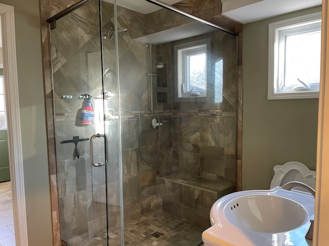 bathroom with sink, a shower with shower door, and toilet