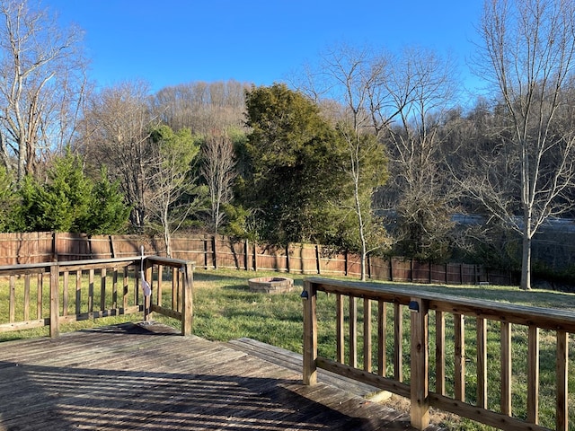 wooden deck featuring a yard and a fire pit