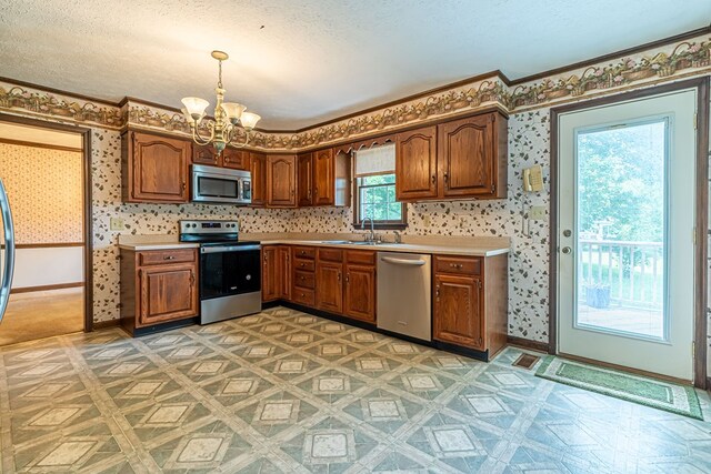 19464 Triple Crown Dr, Abingdon, VA 24211 - kitchen featuring stainless steel appliances, a chandelier, light countertops, a textured ceiling, and ornamental molding