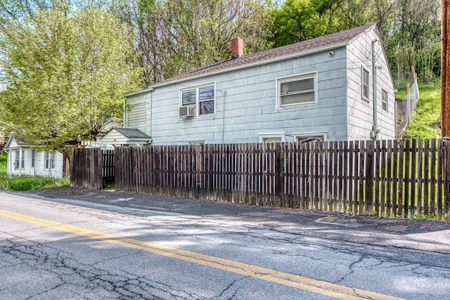 view of side of home featuring fence private yard and a chimney