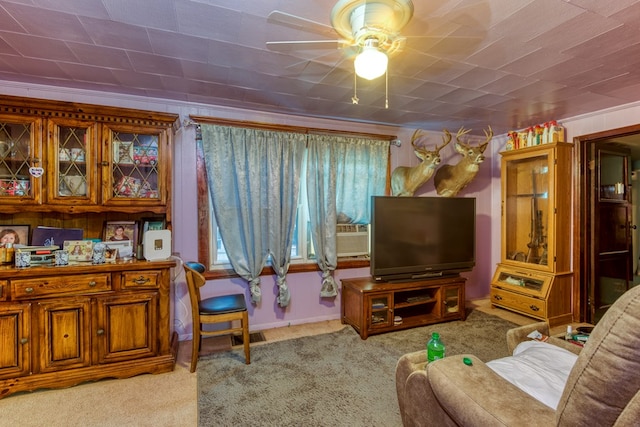 carpeted living room featuring a ceiling fan, baseboards, and plenty of natural light