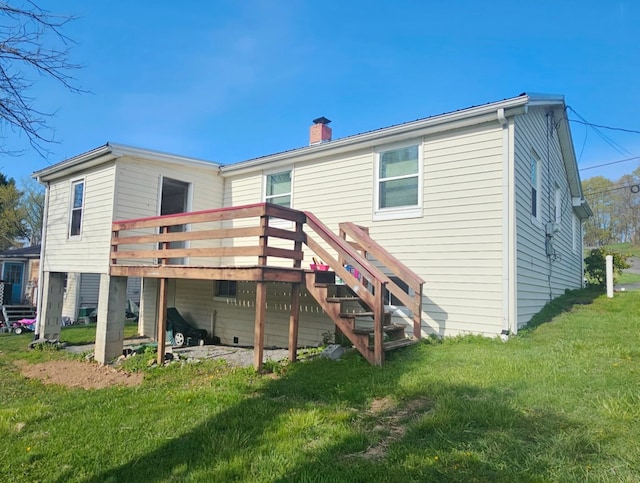 rear view of house featuring a wooden deck, a lawn, a chimney, and stairway