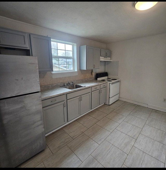 kitchen featuring a sink, freestanding refrigerator, gray cabinetry, under cabinet range hood, and white range with electric stovetop
