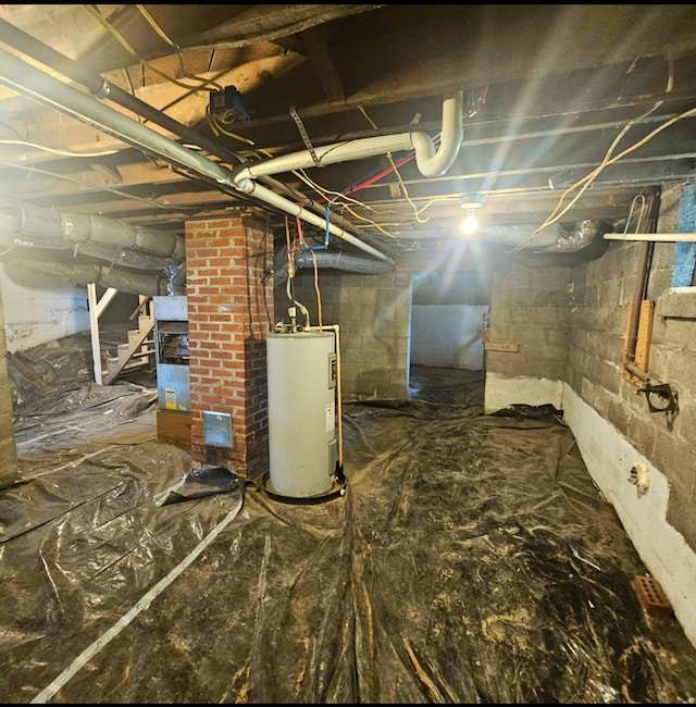 unfinished basement featuring water heater and stairway