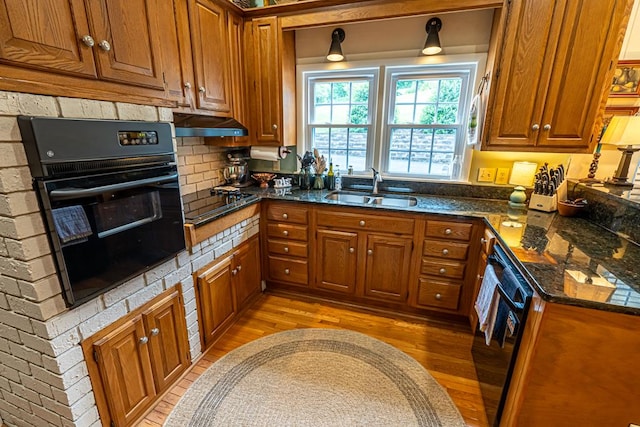 503 Court St, Abingdon, VA 24210 - kitchen with black appliances, brown cabinetry, light wood-type flooring, and under cabinet range hood