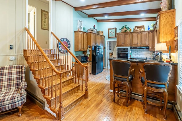 503 Court St, Abingdon, VA 24210 - kitchen featuring black appliances, light wood-style floors, a peninsula, beam ceiling, and decorative backsplash