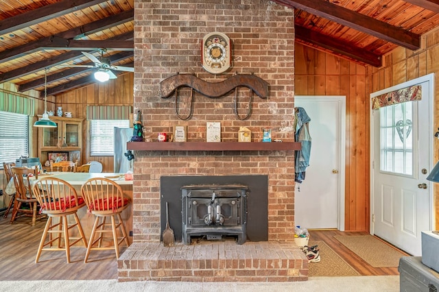 575 Apache Trl, Fancy Gap, VA 24328 - living room with wood walls, wooden ceiling, wood finished floors, a ceiling fan, and a wood stove