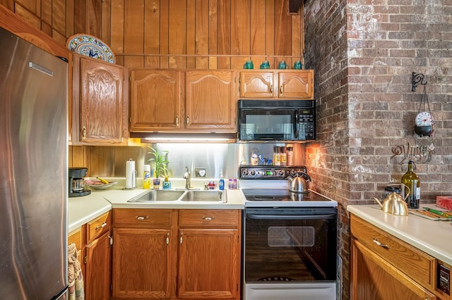 575 Apache Trl, Fancy Gap, VA 24328 - kitchen with black microwave, freestanding refrigerator, range with electric stovetop, light countertops, and brick wall