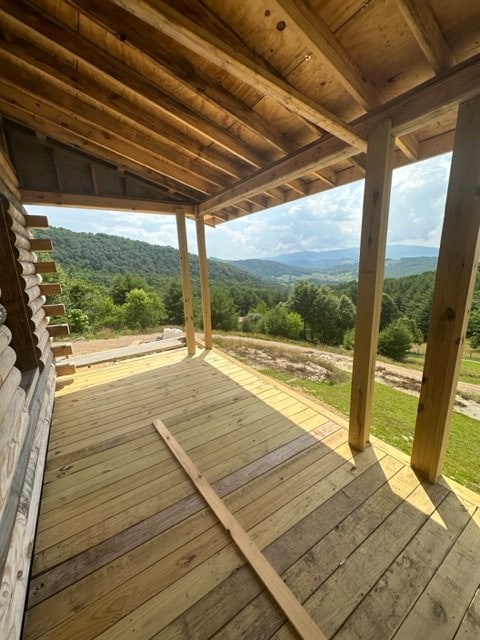 wooden terrace featuring a mountain view and a wooded view