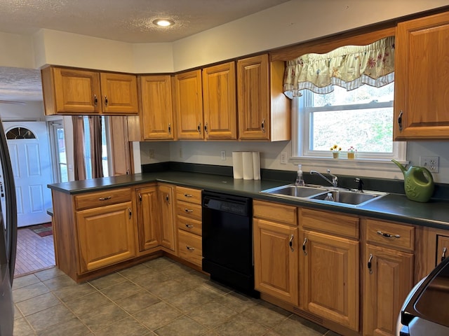 kitchen with a sink, dark countertops, brown cabinetry, and dishwasher