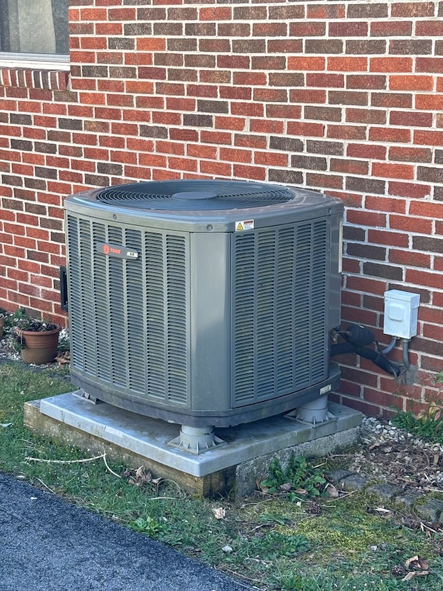 details featuring central air condition unit and brick siding