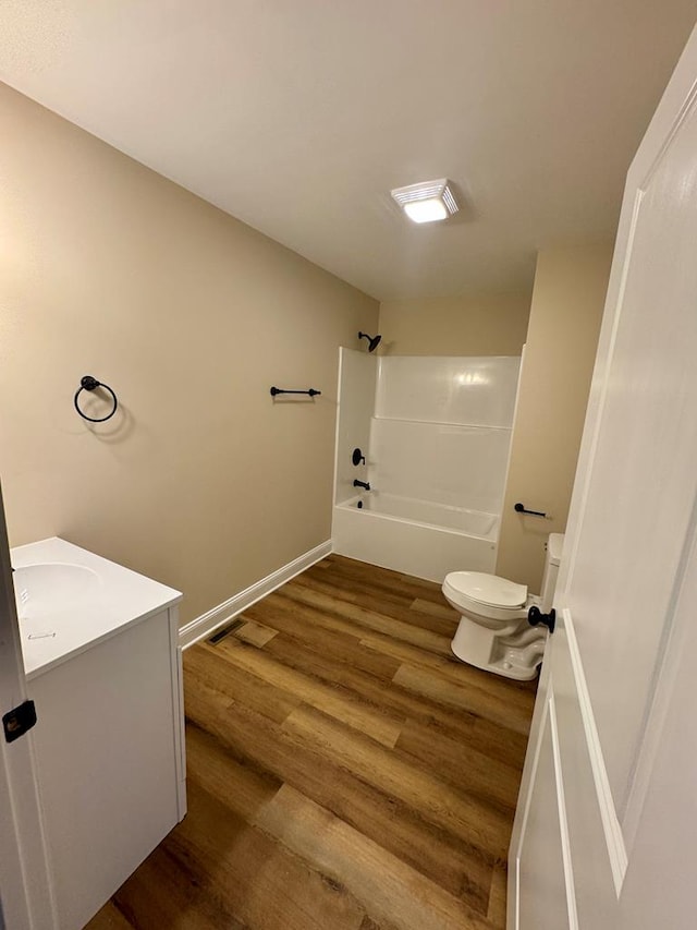 full bathroom with washtub / shower combination, wood finished floors, toilet, and vanity