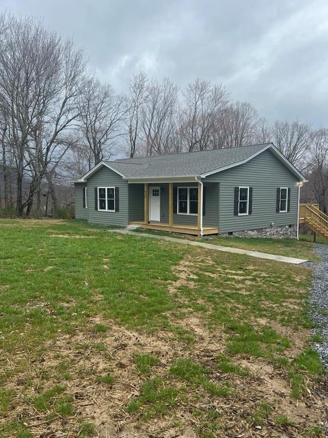 ranch-style house featuring a porch, a shingled roof, and a front yard