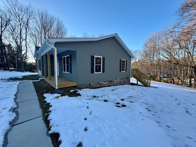 view of snowy exterior with covered porch
