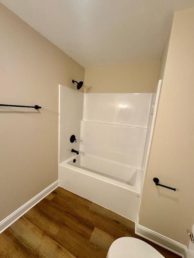 full bathroom with baseboards, toilet, wood finished floors, and shower / bathing tub combination