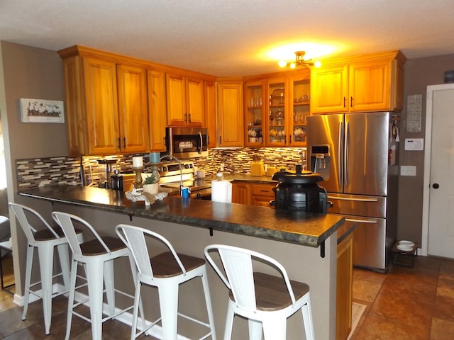 566 Breezy Ridge Rd, Woodlawn, VA 24381 - kitchen with appliances with stainless steel finishes, a peninsula, dark countertops, tasteful backsplash, and glass insert cabinets