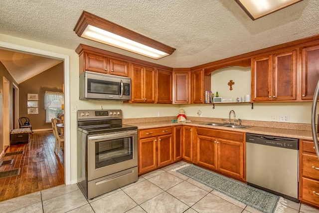 18357 Westwood Dr, Abingdon, VA 24211 - kitchen featuring appliances with stainless steel finishes, light countertops, a textured ceiling, light tile patterned flooring, and open shelves