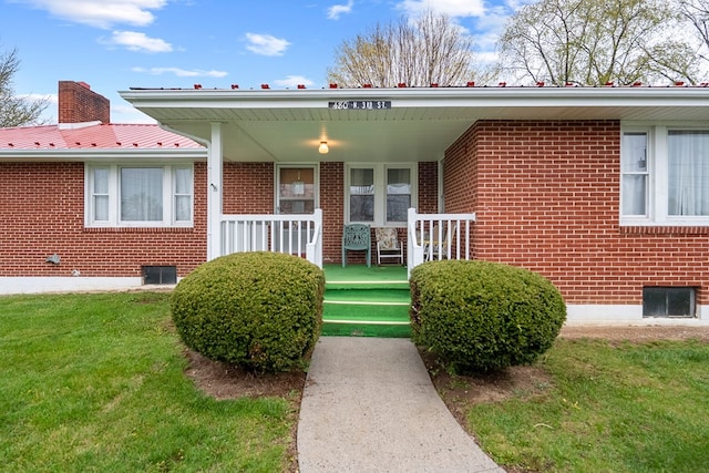 480 N 3rd St, Wytheville, VA 24382 - view of exterior entry with brick siding, a porch, and a yard