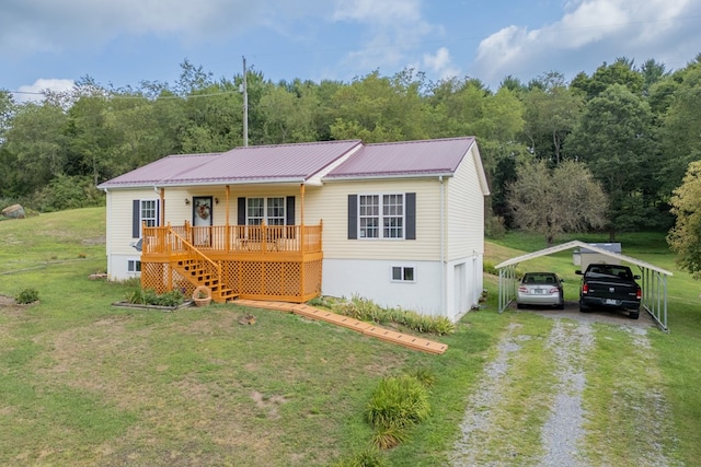 view of front facade with metal roof, covered porch, stairs, driveway, and a detached carport