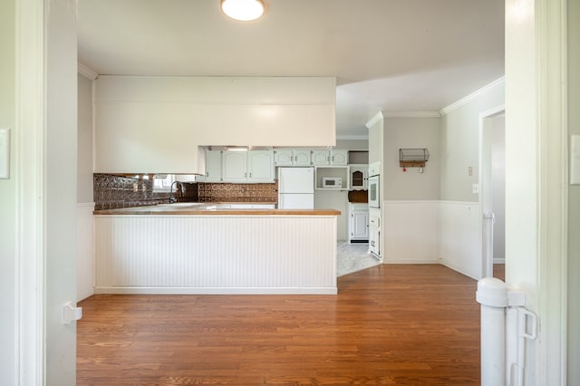 8214 Snake Creek Rd, Hillsville, VA 24343 - kitchen with white appliances, a peninsula, wood finished floors, wainscoting, and crown molding
