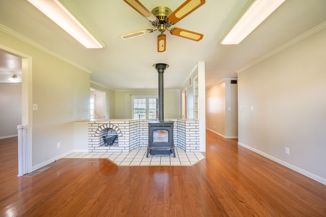 8214 Snake Creek Rd, Hillsville, VA 24343 - unfurnished living room with a wood stove, ceiling fan, wood finished floors, and ornamental molding