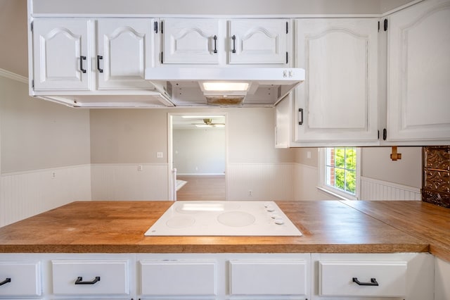 8214 Snake Creek Rd, Hillsville, VA 24343 - kitchen with white electric cooktop, a wainscoted wall, extractor fan, white cabinetry, and a ceiling fan