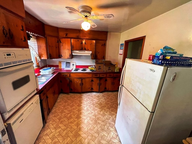 kitchen featuring under cabinet range hood, brown cabinets, white appliances, and ceiling fan