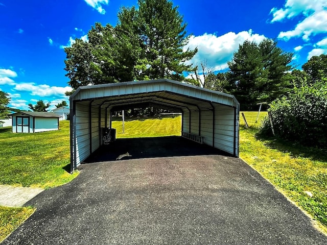 exterior space featuring a carport, a storage unit, and aphalt driveway