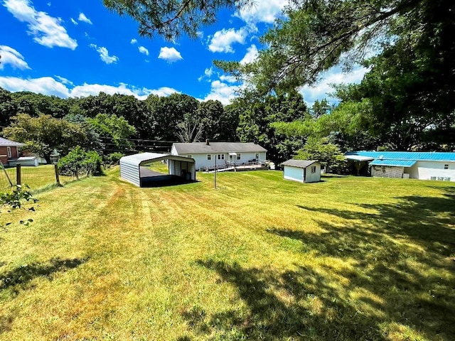 view of yard featuring an outbuilding, a storage unit, and fence