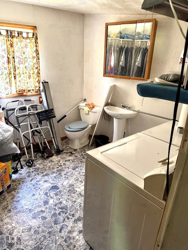 318 Limestone Rd, Pounding Mill, VA 24637 - bathroom featuring independent washer and dryer, toilet, tile patterned floors, a textured wall, and a textured ceiling
